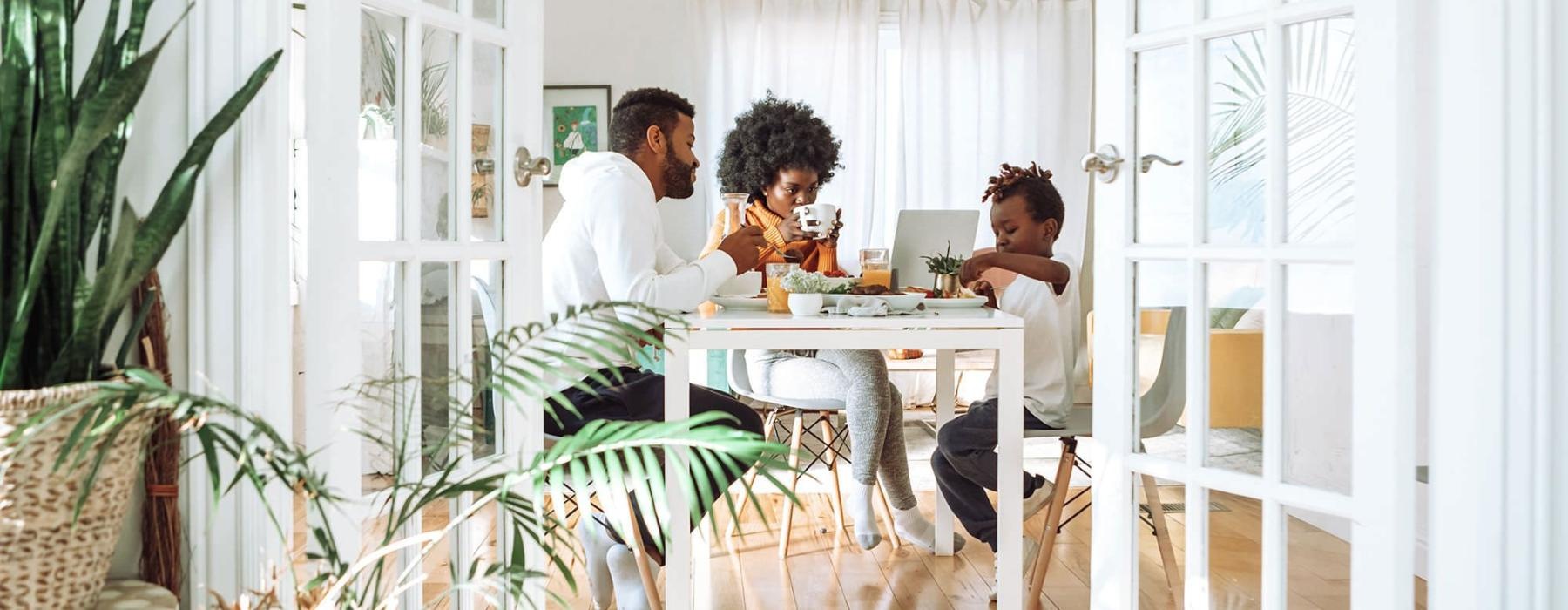 young family of three eat together at the breakfast table